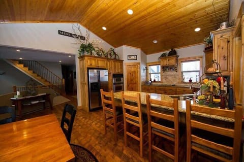 Dining area with a full dining room table and additional seating at the kitchen.