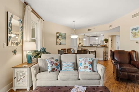 View from tv wall of queen size sleeper sofa, dining area, kitchen & entry 