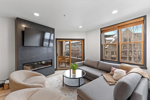 Cozy up in this modern living room where a sleek fireplace meets plush seating, perfect for relaxing after your mountain adventures.