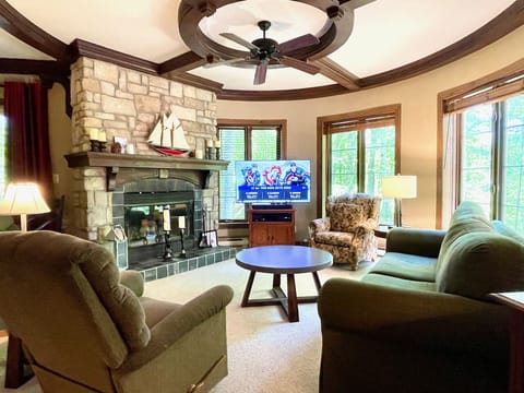 Spacious turret-style living room with stone fireplace