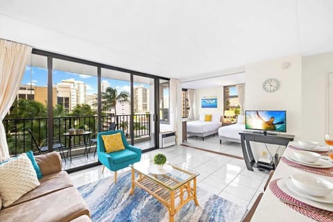 Living room with an open floor plan, fully equipped kitchen, and a balcony!