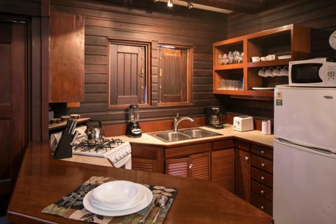 kitchen with tiled and wooden countertops.  windows open to ocean view
