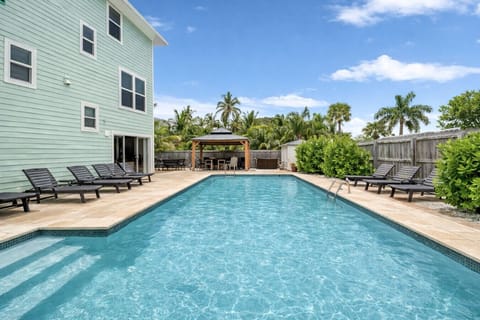Large private heated pool with plenty of lounge chairs and covered outdoor dining area for the whole family