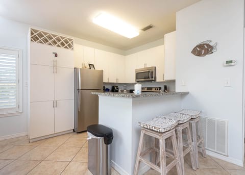 This modern kitchen features stainless appliances, granite countertops, and a cozy breakfast bar for casual dining