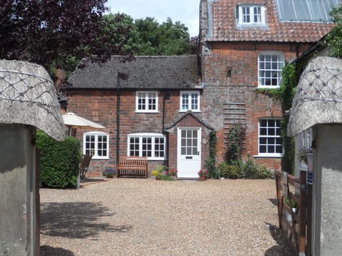 Entrance to the cottage through the thatched wall with patio to the left