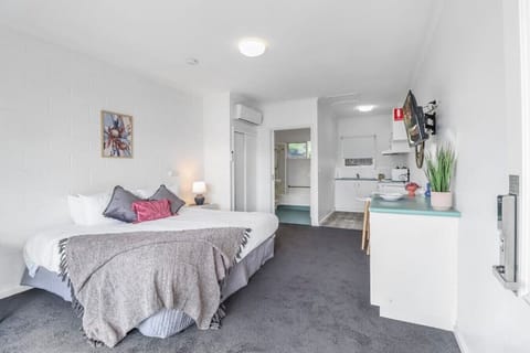 Bright studio-style apartment in Geelong CBD with comfortable bed, kitchenette and modern coastal styling.