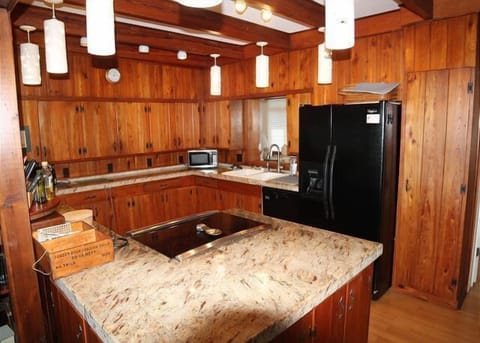 Rustic kitchen with warm wood paneling and modern appliances.