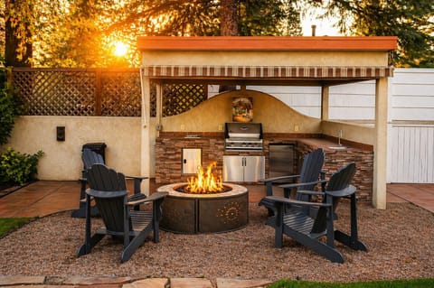 Sunset firepit lounge with outdoor kitchen and cozy Adirondack seating