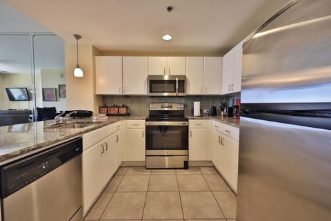 Fully stocked kitchen with stainless steel appliances.
