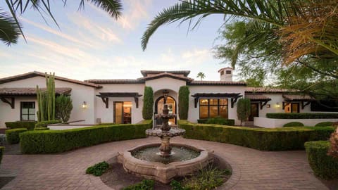 The front entrance features a beautiful water feature and manicured landscaping
