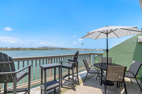Enjoy your morning coffee on this waterfront balcony with stunning bay views and comfortable outdoor seating.