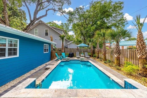 Side of property with lap pool and turquoise lounge chairs