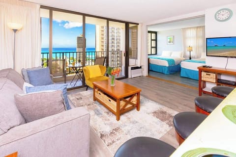 stunning ocean view from the comfort of your own balcony, and a living room with a comfortable sofa bed, and a coffee table.