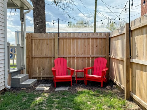 Fenced side yard with seating and twinkle lights