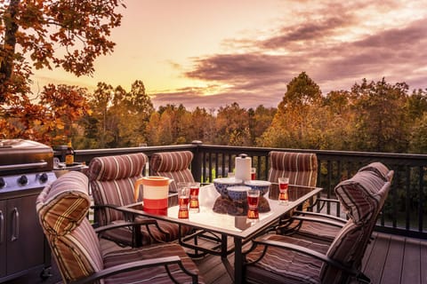 Large deck with propane grill and patio set. Basketball court and field in view