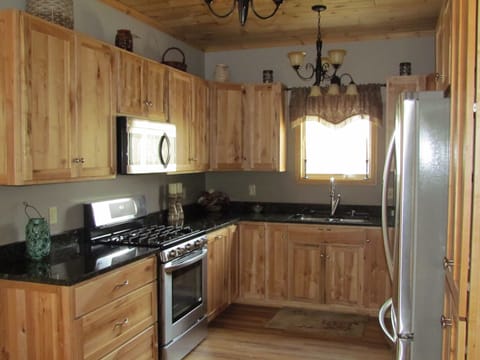 Fully equipped kitchen featuring rustic maple cabinets and granite counter tops.