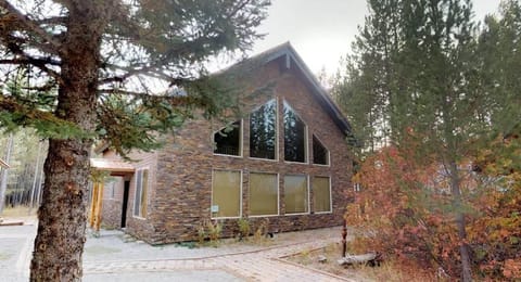 Welcome to North Big Springs Lodge! This stunning stone-accented cabin features beautiful geometric windows and is surrounded by lush, peaceful trees.