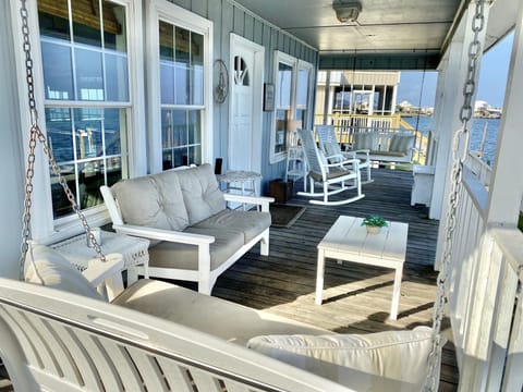 Upper deck features two swings, two rocking chairs, and a small sofa.