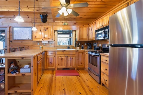 Tile countertops, 1x6 wood plank floor, Moen pull out faucet, large sink and fan