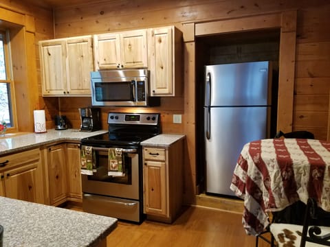 Fully equipped kitchen. coffeepot, toaster, plates, cups, pans, utensils.