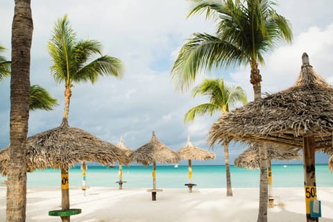 On the beach, white sand, beach cabanas, sun loungers