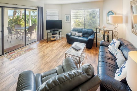 Living Room - View to Porch - Spacious living room with open floor plan and connected patio facing the pool and courtyard.