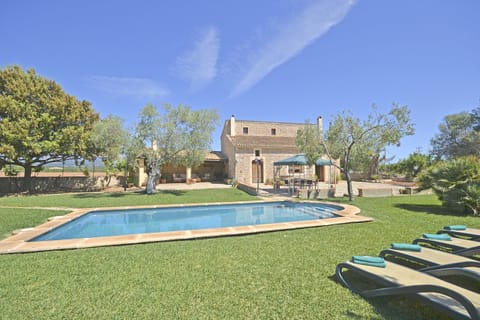 Modern facade of a villa with pool in Mallorca, surrounded by gardens. A perfect space to enjoy exclusive and peaceful vacations on the island.