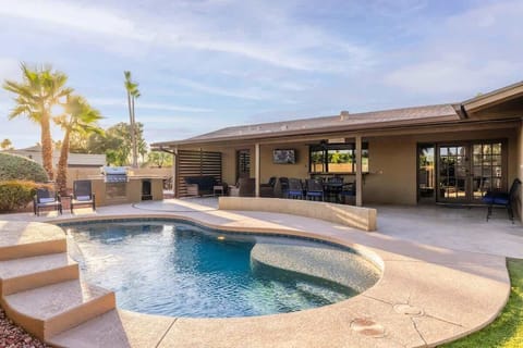 Sparkling pool and hot tub surrounded by desert landscaping and mountain views.