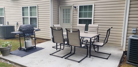 Back patio, table, and gas grill.