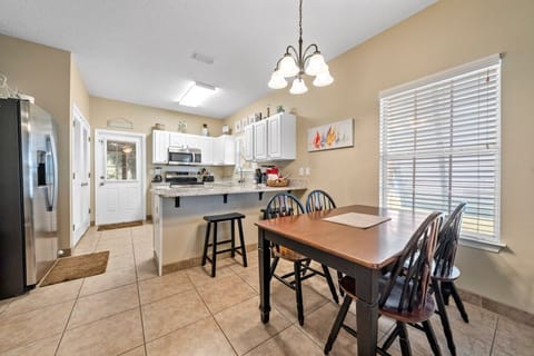 Your fully equipped kitchen opens to a bright dining area where you'll enjoy home-cooked meals together around the welcoming wooden table.