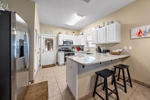 Your fully equipped kitchen features granite countertops, stainless steel appliances, and a breakfast bar perfect for morning coffee or casual meals.