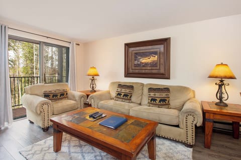 Unwind in your cozy living room with rustic mountain charm, comfortable seating, and peaceful forest views from your private balcony.