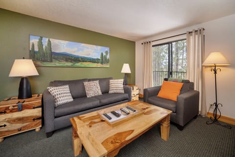 Unwind in your comfortable living room with mountain views from your private balcony and cozy seating for evening relaxation.