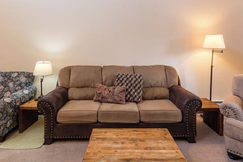 Sink into plush comfort in your spacious living room, complete with cozy seating and warm ambient lighting for perfect relaxation.