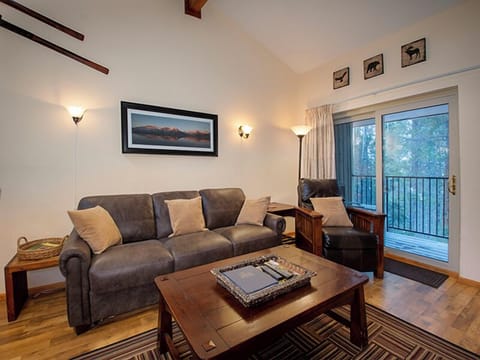 Sink into this cozy living room's plush gray sofa while you enjoy mountain views through the balcony doors.
