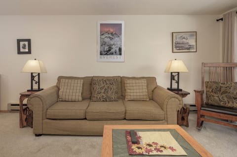 Settle into this cozy living room where warm lamps cast a gentle glow over comfortable seating, perfect for unwinding after your mountain adventures.