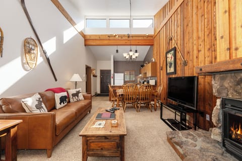 Unwind in your cozy mountain retreat with soaring ceilings, warm wood accents, and a crackling stone fireplace.