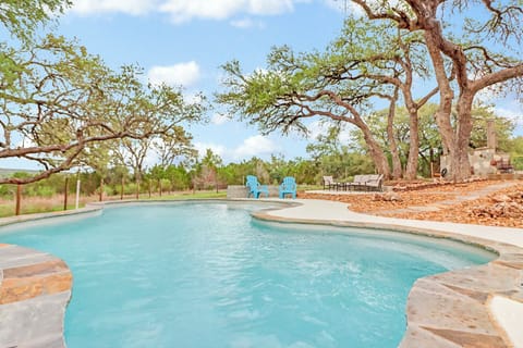 Lounge by the inviting pool, surrounded by towering oak trees