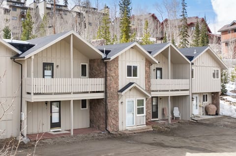 Traditional mountain townhomes nestled in a scenic alpine setting with forest views and convenient access.