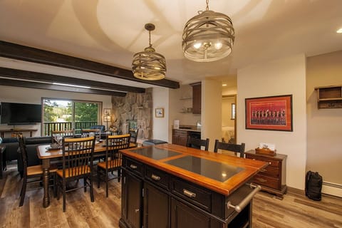 Your open-concept kitchen flows seamlessly into the dining area, featuring exposed beams and statement pendant lighting for memorable gatherings.
