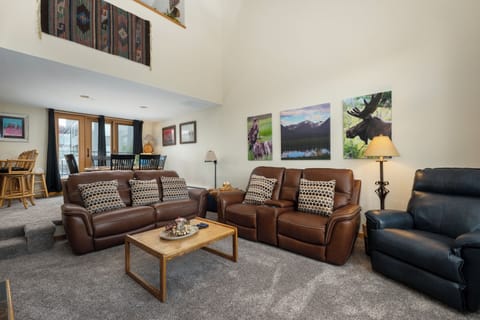 Relax in this spacious living room with plush leather seating and mountain-themed artwork creating your perfect mountain retreat atmosphere.