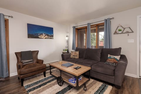 Sink into the plush sofa and unwind in your cozy living room, where mountain artwork and warm touches create the perfect retreat.