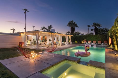 The pool, cabana, hot tub lounge chairs in the evening