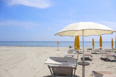 On the beach, white sand, sun loungers, beach umbrellas