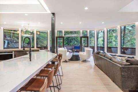 Natural light floods the kitchen and living room, boasting incredible forest views.