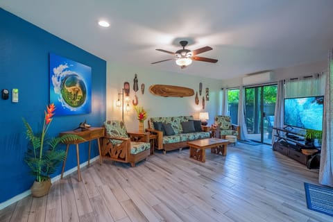 Mauna Kai 5A living room - Mauna Kai 5A has a beautifully updated interior, with real wood floors and locally sourced artwork throughout the unit!