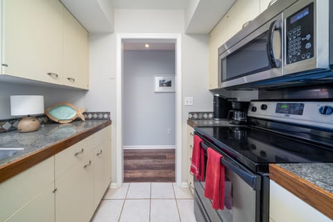 The kitchen has tile counters and stainless appliances.