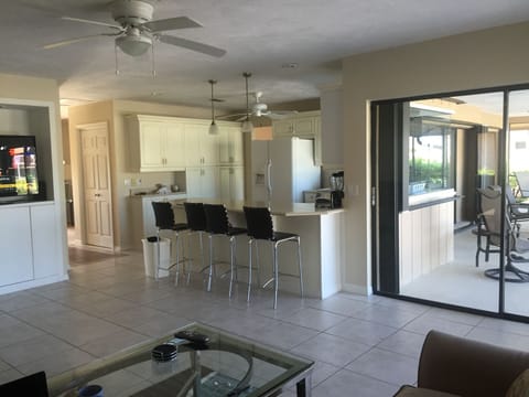 Family room area with 2 sofas, 55" TV, large kitchen countertop.