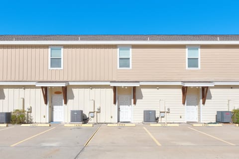 Multi-unit vacation rental building with individual covered entrances and dedicated parking spaces.