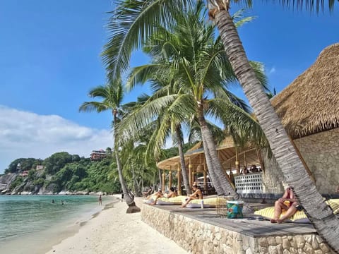 On the beach, white sand, sun loungers, beach umbrellas
